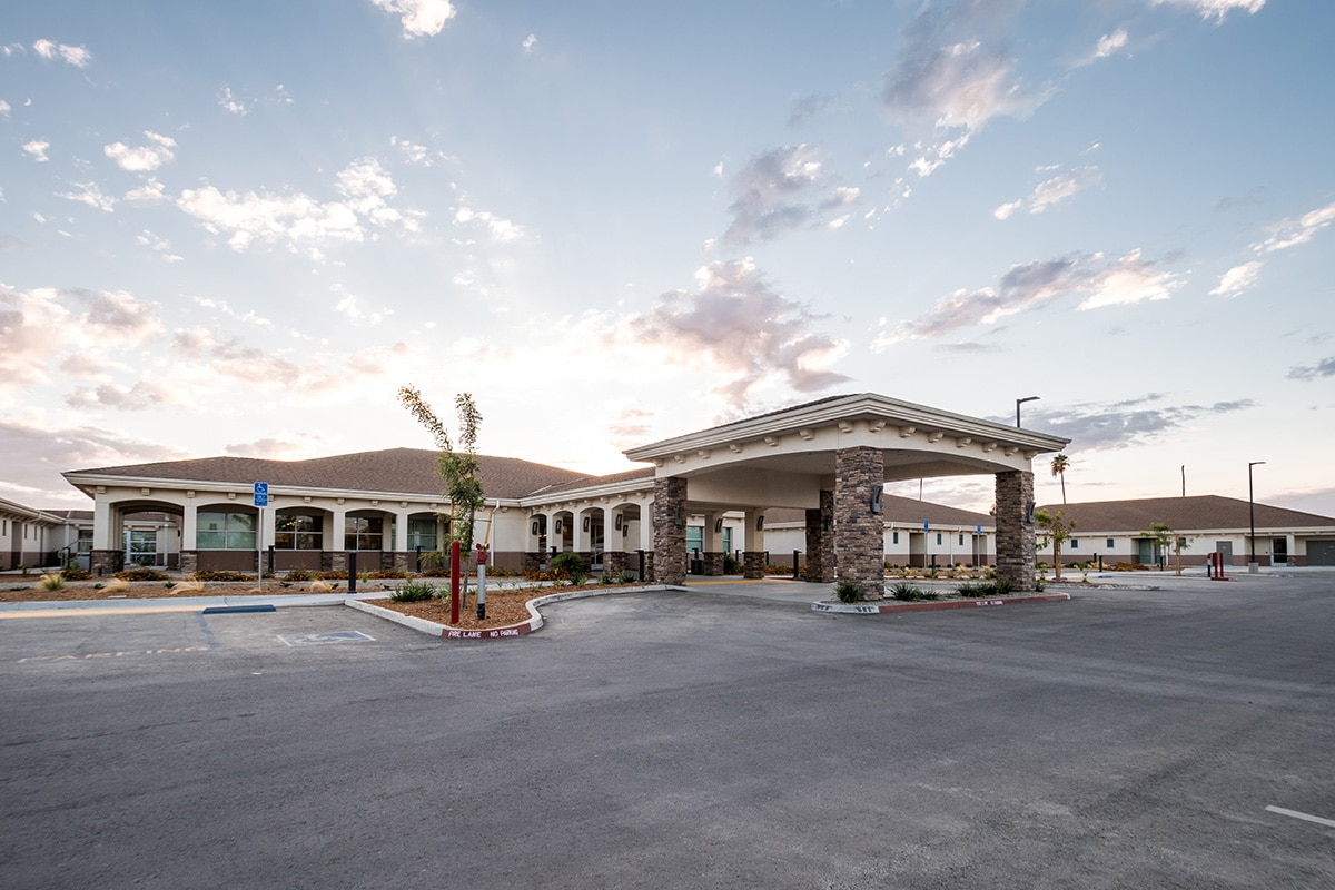 Kern River Transitional Care front entry view at sunset with lit up skies